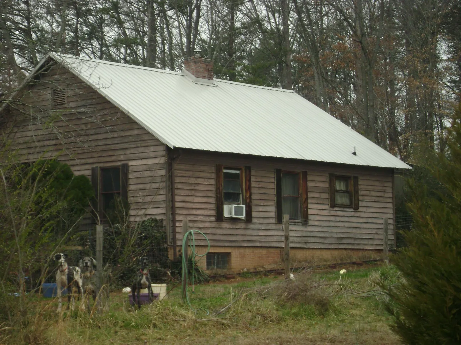 White metal roof on an old wood sided farmhouse, from a Metal Roof Installation job in Saluda
